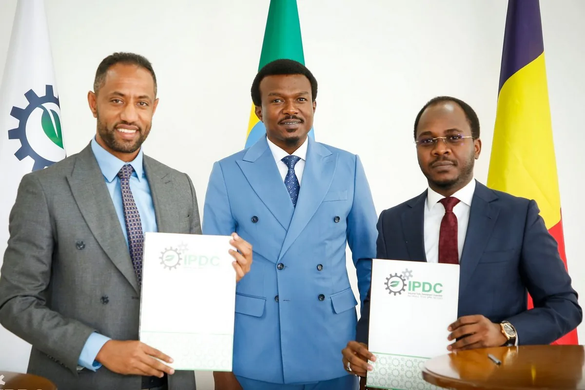 Executives holding signed IPDC agreement folders at the ceremony in Addis Ababa